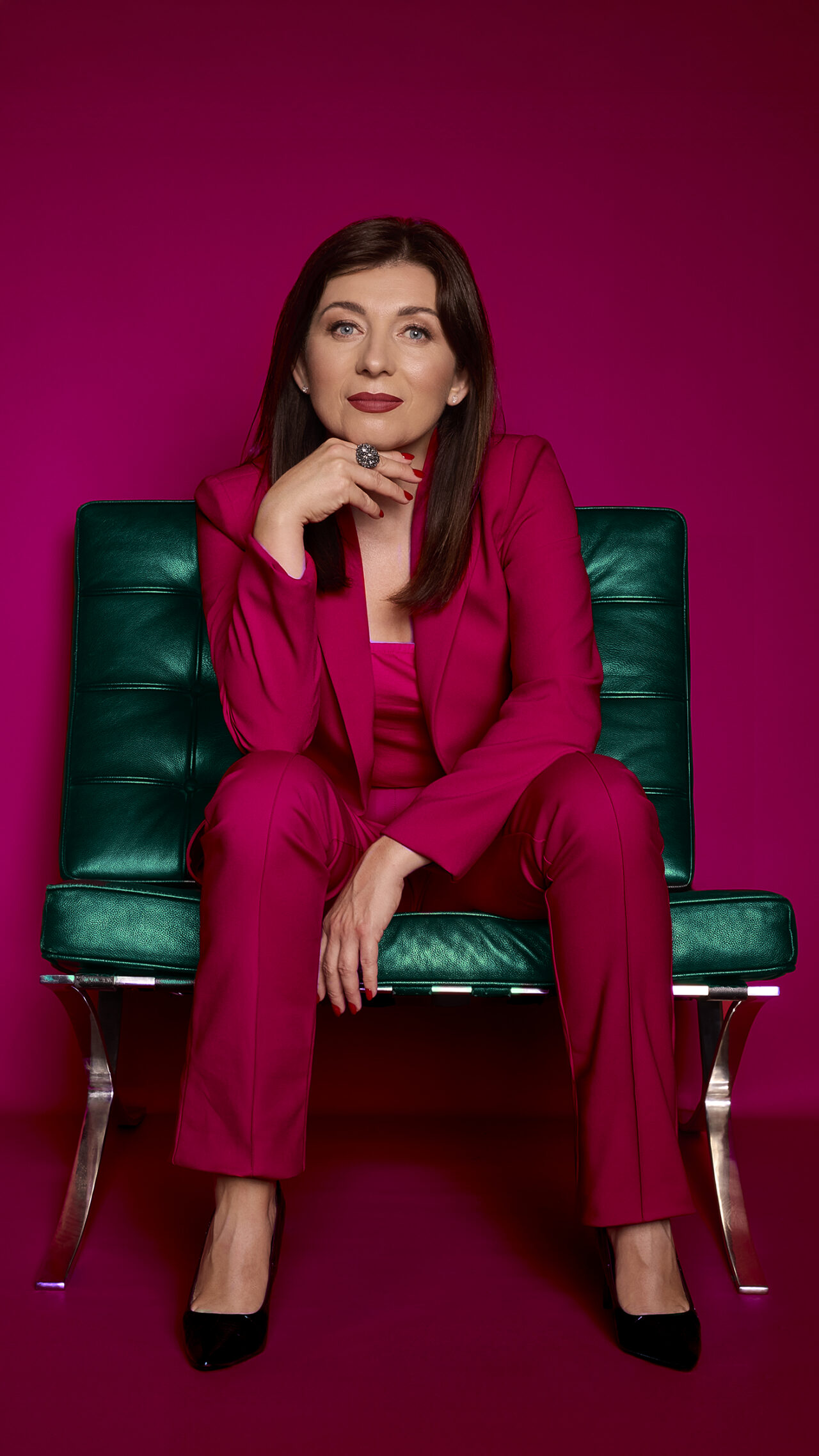 portret wizerunkowy, kobieta w purpurowej marynarce, dłoń przy twarzy, purpurowe tło, wariant ujęcia